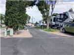 Fifth wheel trailer next to an empty site at COWBOY RV PARK - thumbnail