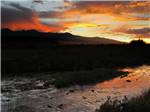 The sunset sky reflecting on the creek at GRAPE CREEK RV PARK CAMPGROUND & CABINS - thumbnail