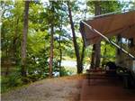 View larger image of A trailer with an open awning overlooking the lake at SOARING EAGLE CAMPGROUND  RV PARK image #6