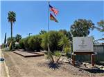 View larger image of Sign entrance with American flag and Good Sam flag at ALMOND TREE OASIS RV PARK image #3