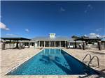 Rectangular pool with elegant building nearby at ST AUGUSTINE RV RESORT - thumbnail
