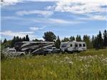 A fifth wheel and travel trailer parked at AIRPORT INN MOTEL AND RV PARK - thumbnail