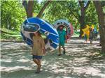 A group of people walking with innertubes - thumbnail