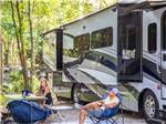 Two campers lounge at table near their RV at THE CAMPGROUND AT JAMES ISLAND COUNTY PARK - thumbnail