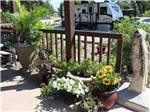 Potted flowers and welcome sign at TRIPLE 'J' RV PARK - thumbnail
