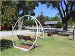 Swinging bench near a fire pit and picnic table at TRIPLE 'J' RV PARK - thumbnail
