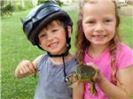 A couple of kids holding frogs at LAKE BLUFF CAMPGROUND - thumbnail