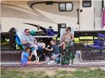 Family and dog sitting next to their RV at JELLYSTONE PARK AT MAMMOTH CAVE - thumbnail