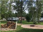 A large fire pit with firewood at ROYAL OAKS RV PARK - thumbnail