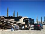 People sitting outside a parked RV at Lifestyle RV Resort - thumbnail