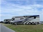 A row of motorhomes parked in sites at CAMP HATTERAS RV RESORT & CAMPGROUND - thumbnail