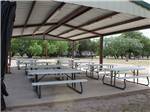 Picnic benches under the large pavilion at FORT CLARK SPRINGS RV PARK - thumbnail