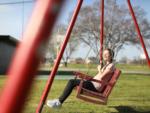 A woman on a bench swing at THE OUACHITA RV PARK - thumbnail