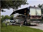 A motorhome in an RV site with it's awning out at LAZY DAY CAMPGROUND - thumbnail