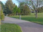 View larger image of Asphalt walking path under lush trees flanked by lawn at ROBIDOUX RV PARK image #9