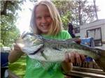 View larger image of A girl holding a fish at LEHMANS LAKESIDE RV RESORT image #7