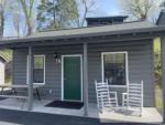 Small cabin with tow rocking chairs at FOOTHILLS RV PARK & CABINS - thumbnail