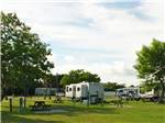 View larger image of RV units parked alongside community picnic tables at SONRISE PALMS RV PARK image #9