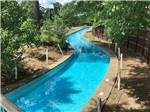 The long Lazy River surrounded by trees at Auburn RV Park and Resort Pools - thumbnail