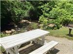 Picnic table by creek with bbq at Auburn RV Park and Resort Pools - thumbnail