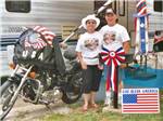 A couple standing next to a motorcycle at AMERICA'S BEST CAMPGROUND - thumbnail