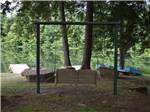 A swinging bench overlooking the water at WOODLAND CAMPGROUND - thumbnail