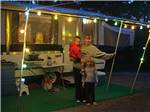 Mother and children outside trailer at night at LAKE BYLLESBY CAMPGROUND - thumbnail
