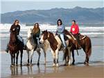 View larger image of Girls riding horses on the beach at PACIFIC DUNES RANCH RV RESORT image #2