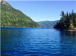 Lake surrounded by mountains with lone kayaker at ELWHA DAM RV PARK - thumbnail