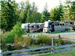 RVs parked in row with wooden fence at ELWHA DAM RV PARK - thumbnail