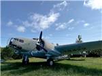 An old fighter plane on the grass at COUNTRY INN MOTEL & TRAILER PARK - thumbnail