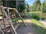 A couple of swinging benches by the water at MOUNTAIN MEADOW RV PARK & CABINS - thumbnail