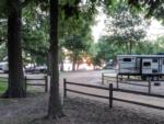 Travel trailer parked on gravel site near a lake at sunset at Lakeshore RV Park - thumbnail