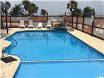 View larger image of A very blue pool with lounge chairs at SEA BREEZE RV COMMUNITY RESORT image #3
