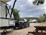 Travel trailer and pickup truck in site with picnic table at TURQUOISE TRAIL CAMPGROUND & RV PARK - thumbnail