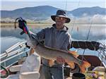 A man holding a fish he caught - thumbnail
