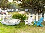 Two chairs and a boat on the grass at AMERICAN SUNSET RV & TENT RESORT - thumbnail