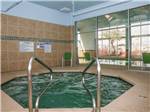 View larger image of Indoor hot tub with green chairs nearby at COTTON LANE RV RESORT image #7