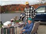 A man and woman in front of the water at COZY C RV CAMPGROUND - thumbnail