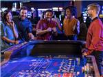 View larger image of Two couples playing at the table games at PARAGON CASINO RV RESORT image #12