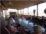 A group of people sitting at a long table outside at PATO BLANCO LAKES RV RESORT - thumbnail