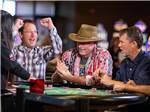 View larger image of A man cheering on a winner at a card table at WILDHORSE RESORT  CASINO RV PARK image #5
