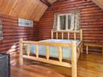 A rustic bedroom inside a rental cabin at THE NUGGET RV RESORT - thumbnail