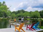 Colored Adirondack chairs on a dock at SPRING LAKE RV RESORT - thumbnail