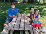 View larger image of Happy family at a picnic table at TOWN MOUNTAIN TRAVEL PARK image #6