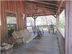 A swinging chair and rocking chairs on the deck at COUNTRY OAKS RV PARK & CAMPGROUND - thumbnail