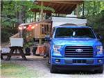 A truck and trailer in an RV site at WOODSMOKE CAMPGROUND - thumbnail