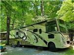 A motorhome in a gravel RV site at WOODSMOKE CAMPGROUND - thumbnail