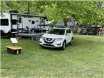 A car parked in a grassy RV site at SMOKY MOUNTAIN MEADOWS CAMPGROUND - thumbnail
