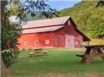 A large red barn and picnic tables at SMOKY MOUNTAIN MEADOWS CAMPGROUND - thumbnail